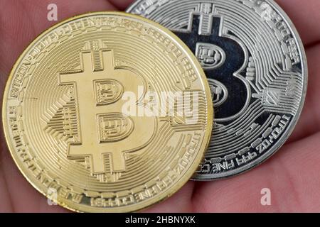 Moneta di criptovaluta Bitcoin tenuta in cima ad una mano. Bitcoin è una criptovaluta, una valuta digitale. Foto Stock