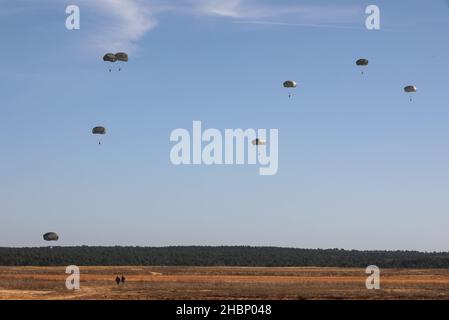 I paracadutisti dell'esercito degli Stati Uniti assegnati alla Divisione Airborne 82nd discendono da un chinook CH-47 (non nella foto) durante un esercizio aereo alla zona di goccia della Sicilia, Fort Bragg, Carolina del Nord, 15 dicembre 2021. Il comando US Army Civil Affairs and Psychological Operations Command (Airborne) della U.S. Army Reserve e 824th Quartermaster Company hanno collaborato con i soldati della 82nd Airborne Division per condurre un'operazione aerea non tattica con un maestro di salto alleato al fine di mantenere la competenza e guadagnare ali di salto all'estero, 13-15 dicembre 2021. (STATI UNITI Esercito foto di SPC. Cody ricco) Foto Stock