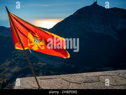 Sbattendo nel vento al parco nazionale di Lovcen, in piedi con orgoglio nei colori rosso e oro vicino al Mausoleo di Njegos, un'importante destinazione turistica e la res Foto Stock