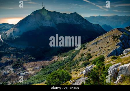 Vista dalla cima del Monte Lovcen al Mausoleo di Njego, guardando verso ovest e retroilluminata dal sole del tardo pomeriggio estivo. Foto Stock