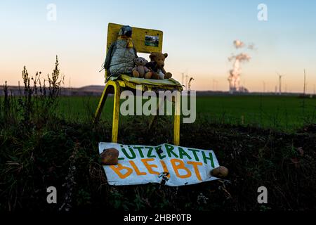 Luetzerath, Germania. 20th Dic 2021. La centrale elettrica alimentata a lignite di Neurath è vista dietro i giocattoli di peluche posti su una strada a Luetzerath da ambientalisti che combattono per la sopravvivenza del villaggio e una fermata di estrazione a Tagebau Garzweile. Le centrali elettriche a carbone in Germania saranno gradualmente eliminate entro il 2038 al più tardi per soddisfare l'obiettivo di 1,5 gradi sul clima. Credit: Matthias Oesterle/Alamy Live News Foto Stock