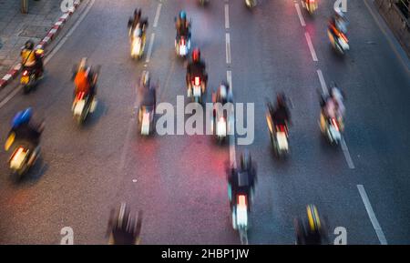Immagine sfocata delle motociclette su una strada a Bangkok Foto Stock