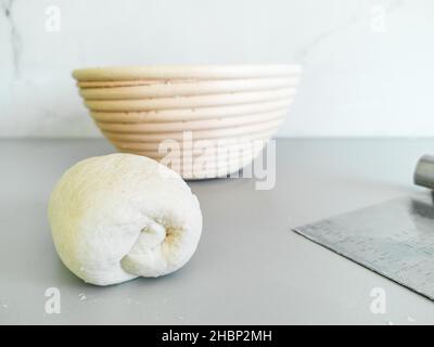 Vista ravvicinata del pezzo di pasta arrotolato sul tavolo vicino al cestello Foto Stock
