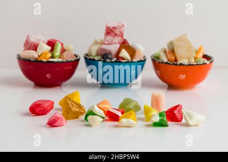 Tradizionale turco dolce Akide sulla linea di fronte a ciotole colorate in ceramica su sfondo bianco Foto Stock