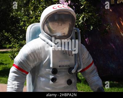 Russia, Sochi 01.05.2021. Scultura di un astronauta con l'iscrizione URSS sul casco sullo sfondo di alberi verdi nel parco al sole Foto Stock