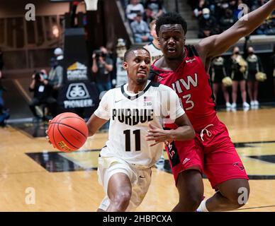 West Lafayette, Indiana, Stati Uniti. 20th Dic 2021. Purdue Boilermakers guardia Isaiah Thompson (11) guida oltre Incarnate Word Cardinals guardia Josh Morgan (13) sulla strada per il cestino nella prima metà del gioco tra gli Incarnate Word Cardinals e i Purdue Boilermakers alla Mackey Arena a West Lafayette, Indiana. Credito obbligatorio: Sandra Dukes/CSM/Alamy Live News Foto Stock