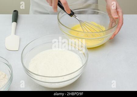 Montare gli albumi e i tuorli in ciotole di vetro da vicino sul tavolo da cucina. Processo di cottura, passo per passo torta di cioccolato ricetta Foto Stock