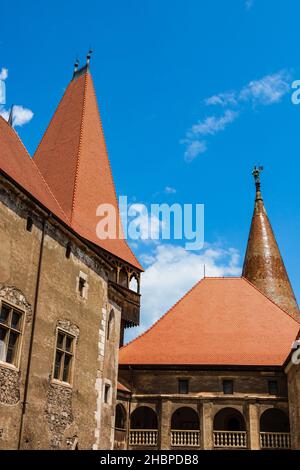 Un colpo verticale di un castello gotico Corvin sotto un cielo blu in Transilvania, Romania Foto Stock