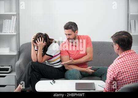 Psicologo dell'operaio sociale che parla con la giovane coppia. Coppia che dice allo psicologo circa i problemi della famiglia coniugale. Consulenza matrimoniale, coniugale Foto Stock