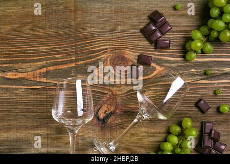 Due bicchieri di vino rosso, uva verde e cioccolato, vista dall'alto Foto Stock