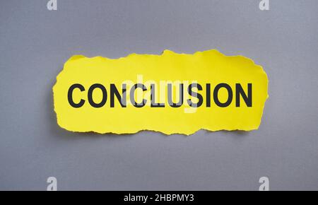 Conclusione. Testo all'interno di carta strappata gialla. Vista dall'alto, disposizione piatta. Foto Stock