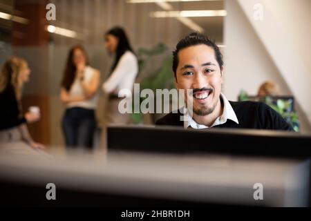 Ritratto di imprenditore sorridente lavoro in ufficio Foto Stock