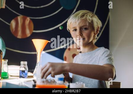 Ritratto di ragazzo facendo esperimento scientifico a casa Foto Stock