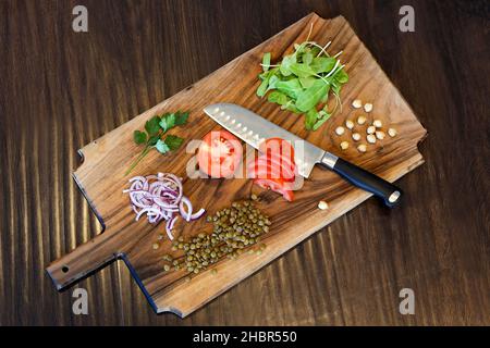 Verdure appena tagliate su un tagliere con un coltello dello chef Foto Stock