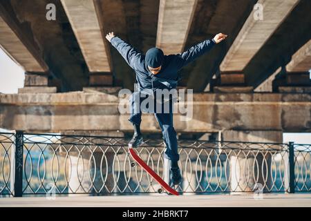 Skateboarder fare un trucco sullo sfondo urbano della strada. Concetto di sport estremi Foto Stock