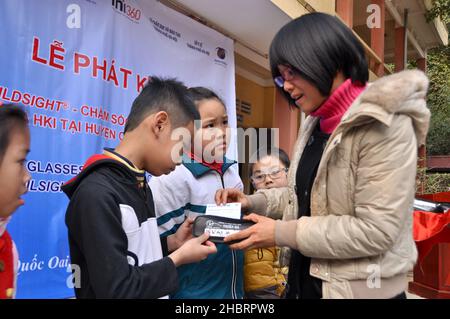 2010s Vietnam: USAID sostiene la distribuzione di occhiali a studenti e insegnanti a Quoc OAI, Hanoi. CA. 23 dicembre 2013 Foto Stock