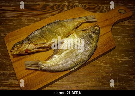 Pesce essiccato su un tagliere di legno Foto Stock