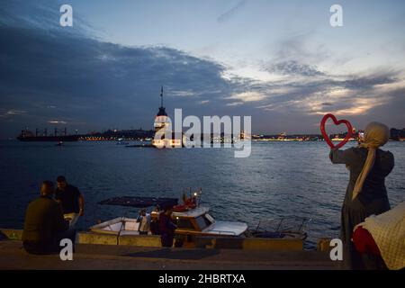 I residenti godono durante il tramonto a Istanbul, Turchia il 21 dicembre 2021 come Maiden's Tower è visto sullo sfondo. La lira turca ha guadagnato ulteriore forza ed è aumentata martedì, continuando la sua ripresa storica dai minimi storici, dopo che il presidente Recep Tayyip Erdogan ha rivelato un piano che avrebbe garantito i depositi nella valuta locale contro la volatilità del mercato. (Foto di Mouneb Taim/INA Photo Agency/Sipa USA) Foto Stock