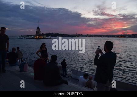 I residenti godono durante il tramonto a Istanbul, Turchia il 21 dicembre 2021 come Maiden's Tower è visto sullo sfondo. La lira turca ha guadagnato ulteriore forza ed è aumentata martedì, continuando la sua ripresa storica dai minimi storici, dopo che il presidente Recep Tayyip Erdogan ha rivelato un piano che avrebbe garantito i depositi nella valuta locale contro la volatilità del mercato. (Foto di Mouneb Taim/INA Photo Agency/Sipa USA) Foto Stock