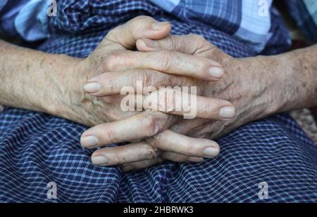 Mani aggrappate di vecchio Myanmar asiatico. Concetto di artrite reumatoide, osteoartrite o dolore articolare. Foto Stock