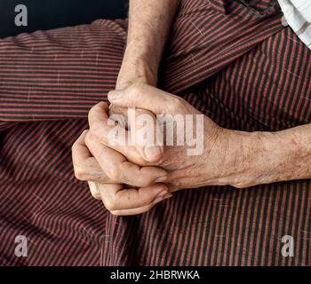 Mani aggrappate di vecchio Myanmar asiatico. Concetto di artrite reumatoide, osteoartrite o dolore articolare. Foto Stock