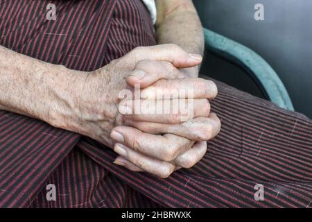 Mani aggrappate di vecchio Myanmar asiatico. Concetto di artrite reumatoide, osteoartrite o dolore articolare. Foto Stock
