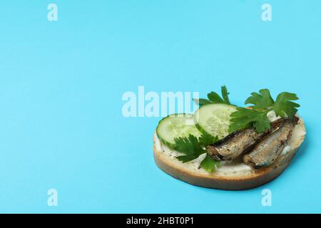 Gustoso sandwich con spratti su sfondo blu Foto Stock