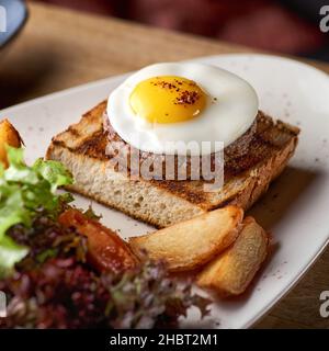 Uova strapazzate con bistecca - classica colazione inglese con uova e patate a spicchi Foto Stock