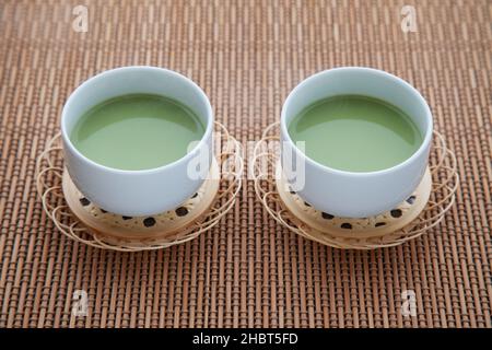 tè verde caldo con latte matcha latte isolato sul tavolo Foto Stock