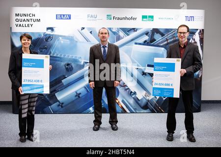 21 dicembre 2021, Baviera, Garching: Hubert Aiwanger, Ministro dell'economia e Presidente di Stato dei liberi elettori in Baviera (M), è tra Claudia Eckert (l), Direttore dell'Istituto Fraunhofer per la sicurezza applicata e integrata (AISEC), E Florian Marquardt, responsabile del Dipartimento di Teoria dell'Istituto Max Planck per la fisica della luce, dopo aver consegnato notifiche di finanziamento all'Istituto Max Planck per l'ottica quantistica. Il Ministro dell'economia bavarese Aiwanger (Free votanti) visita l'istituto in occasione della consegna delle notifiche per la tecnologia quantistica Foto Stock