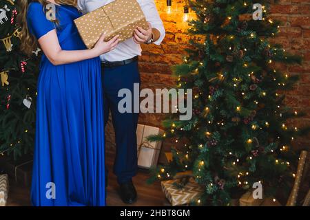 Albero di Natale. Coppia che decora albero di natale. Felice Anno Nuovo. Buon Natale. Vacanze invernali. Miracolo di Natale. Regali. Tradizioni invernali. Arredamento Foto Stock