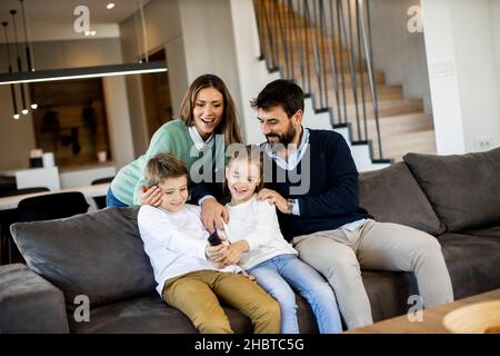 Simpatici fratelli che combattono a casa con il telecomando della TV Foto Stock