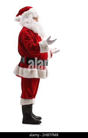 Scatto di Babbo Natale a tutta lunghezza gesturando con le mani e parlando isolato su sfondo bianco Foto Stock