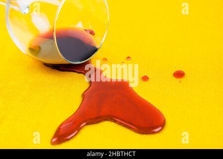 un bicchiere di vino versato sulla tovaglia. Pulizia di vestiti e mobili da macchie Foto Stock