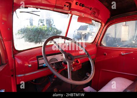 Cruscotto con volante e interno di un vecchio pick up Chevrolet rosso dal 1942 Foto Stock