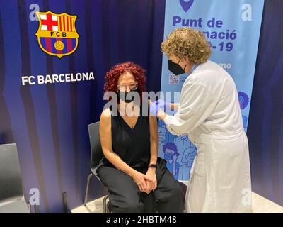 La persona viene vista vaccinata davanti al simbolo del FC Barcelona.per accelerare la vaccinazione del COVID-19, il Futbol Club Barcelona ha offerto un Foto Stock