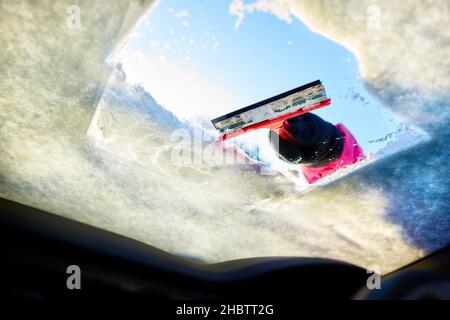 Il conducente sgombrare la neve dal parabrezza Foto Stock