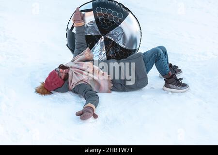 Giovane donna con snow tubing attività invernale, scivolo da neve hi Foto Stock