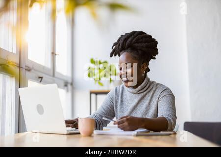 Donna che lavora su un notebook nel suo ufficio Foto Stock