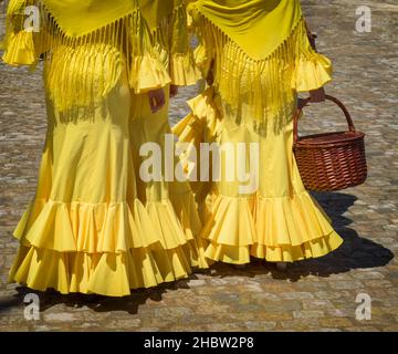 Siviglia, Provincia di Siviglia, Andalusia, Spagna meridionale. Feria de Abril, la Fiera di aprile. Ragazze in abiti giallo flamenco. Foto Stock
