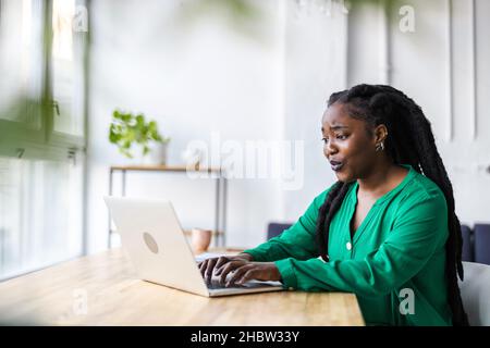 Donna che lavora su un notebook nel suo ufficio Foto Stock