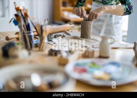 Primo piano di artigiani che lavorano in ceramica in officina Foto Stock