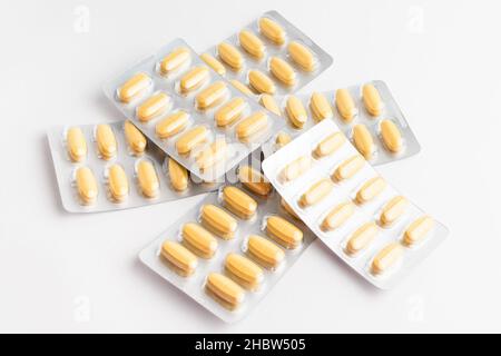 Primo piano di diversi farmaci pillole, compresse e vitamine isolato su sfondo bianco, immagine farmaceutica scattata con soft focus Foto Stock
