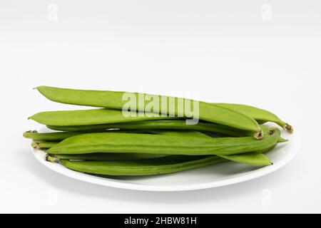 Flat Long Green Runner Beans conosciuto come Jhar SIM, Falia, Keralan, SEM Ki Phali, Sorti Papdi, Guar Ki Fali, Gawar isolato su sfondo bianco. Vegetale Foto Stock