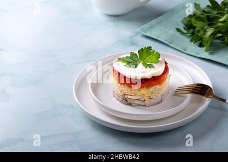 Insalata tradizionale russa con aringhe e verdure su sfondo verde Foto Stock