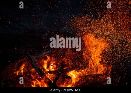 Miliardi di scintille in aumento da un potente falò, effetto spaziale colorato Foto Stock