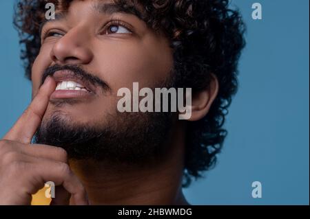 Triste uomo bearded riccio-pelo con una bocca aperta che guarda in su Foto Stock