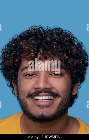 Ragazzo allegro con bocca aperta che mostra i suoi denti bianchi Foto Stock