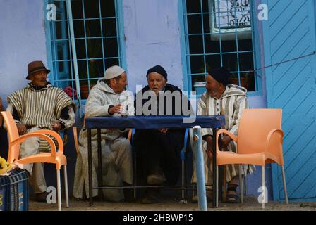 Uomini marocchini seduti in un locale negozio di tè a Chefchaouen, Marocco. Foto Stock