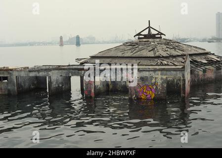 Un edificio della moschea che è stato abbandonato per decenni a causa dell'aumento del livello del mare, l'abrasione costiera e la sussistenza della terra sulla zona costiera di Jakarta, Indonesia. Foto Stock